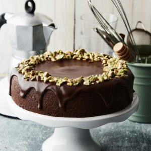 Indulge in this luxurious chocolate cake topped with crunchy pistachios.